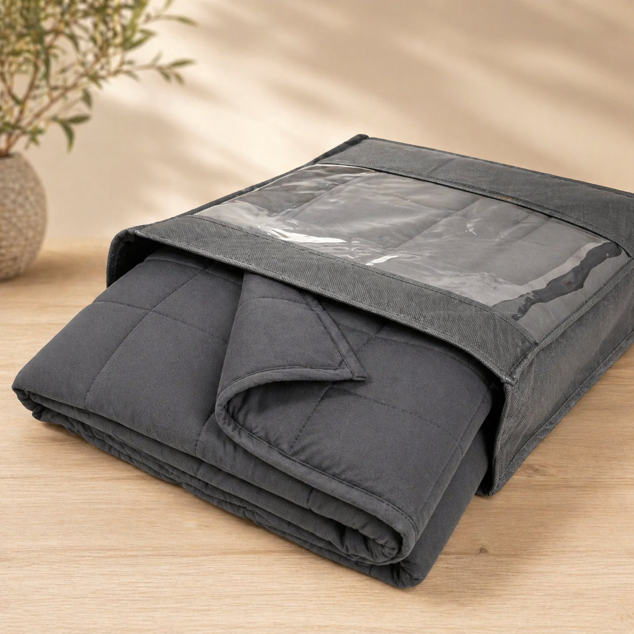 Couverture lestée Someira sortant de son emballage de rangement, fond bois clair