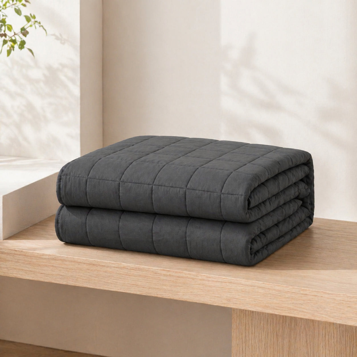 Couverture lestée Someira pliée sur un banc minimaliste, ambiance épurée