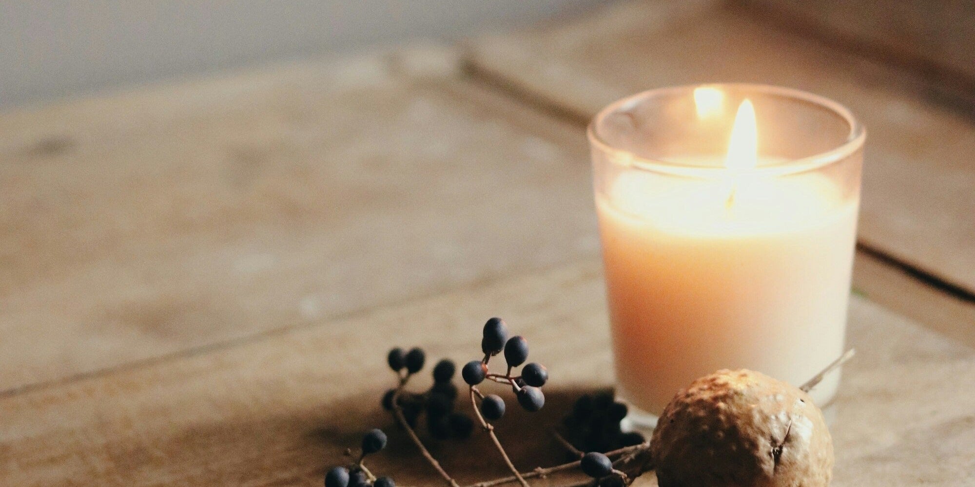 Bougie allumée sur table en bois, ambiance soir Someira