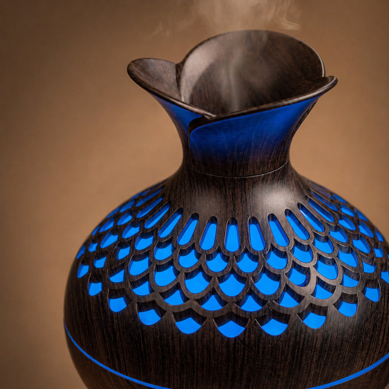Détail du bois sculpté du diffuseur Someira avec brume et lumière bleue